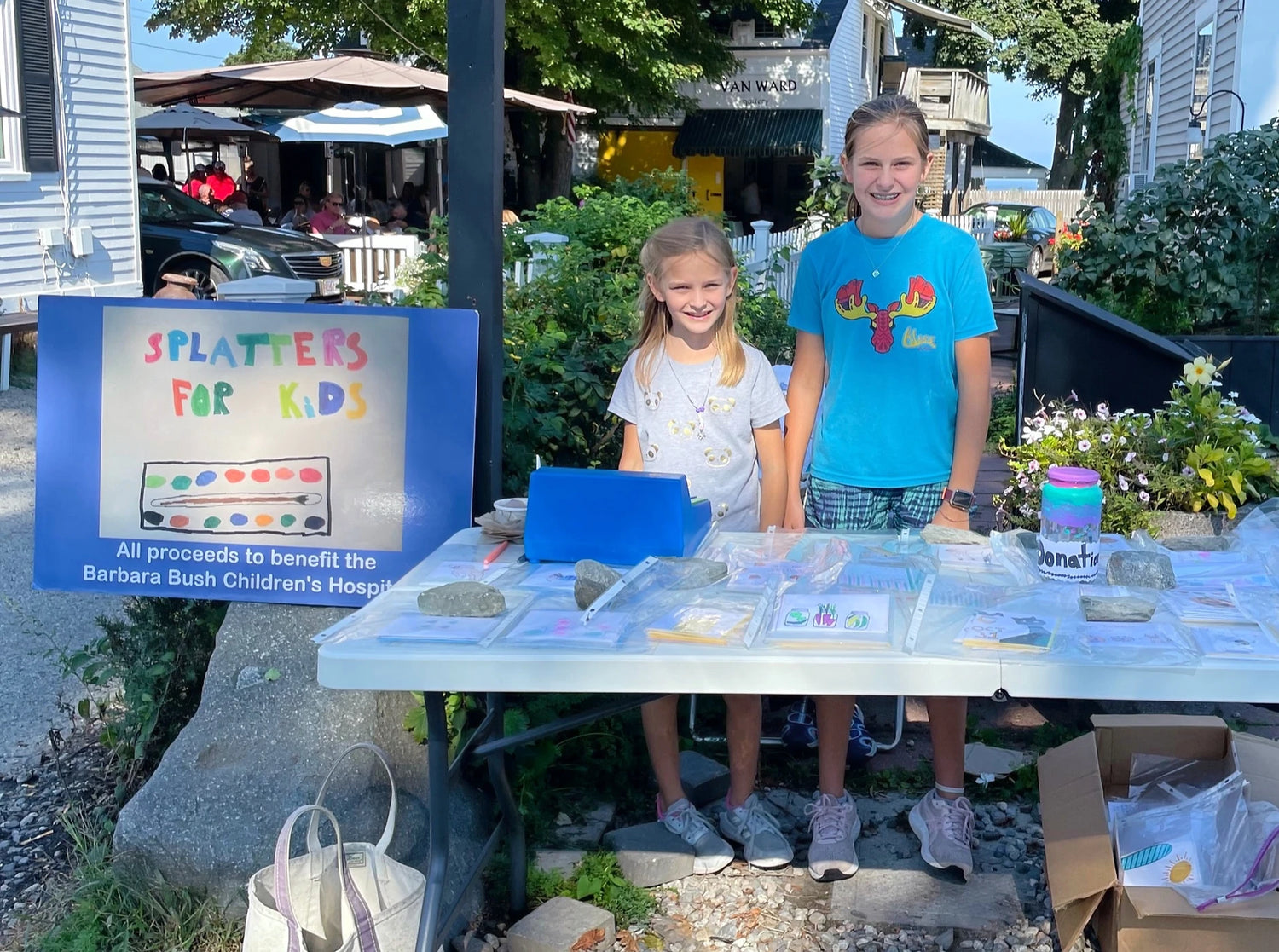 Artist sisters, at their marketplace table, selling Splatters for Kids notecards